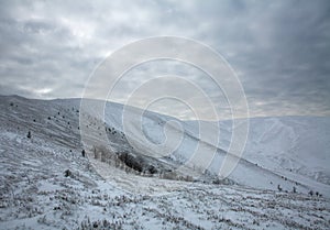 Gloomy landscape in winter snow mountains on gray sky
