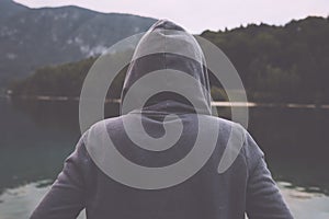 Gloomy sad woman standing by the lake