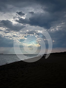 Gloomy sky on the beach with a hole in the clouds