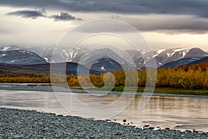 The gloomy sky over the mountains and river.