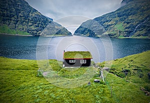 Gloomy summer view of Saksun village with traditional turf-top house. Wonderful evening scene of Pollurin Laguna, Faroe Islands, K