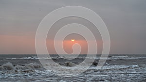 Gloomy sunrise at stormy sea landscape