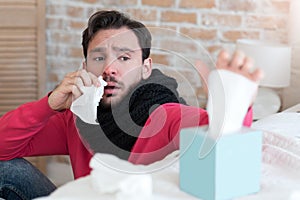 Gloomy tired man taking a tissue out of the box