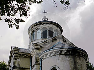 Gloomy view of the Sainte-Beatrix chapel, closeup, against the dark evening sky with heavy rain clouds photo