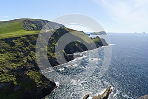 Glorious Irish Coastal Serenity: Emerald Cliffs Bathed in Radiant Light, Under blue Skies