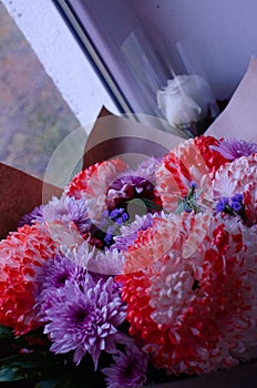 Glorious pastel pink bouquet of peonies in glass jug on floor by window. Flowers in interior design. Cozy home