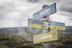 glory to ukraine text quote on wooden signpost outdoors, written on the ukranian flags