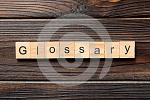 Glossary word written on wood block. Glossary text on wooden table for your desing, Top view concept