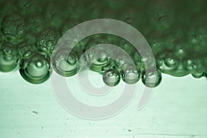 Glossy, light green background with an abundance of soap bubbles, creating a dreamy effect