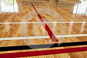 Glossy varnished sprung wooden floor for sports, basketball, gymnastics, gymnasium with court lines marked. photo