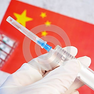 Glove on background of the Chinese flag, vaccine against coronavirus