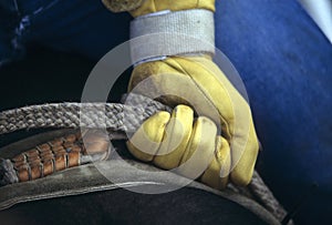 Glove of rodeo cowboy gripping rope photo