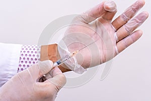 Gloved doctor hands holding an injection vial of a hyaluronic acid HA based dermal filler for anti-aging and volumizing face photo