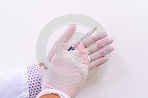 Gloved doctor hands holding an injection vial of a hyaluronic acid HA based dermal filler for anti-aging and volumizing face tre