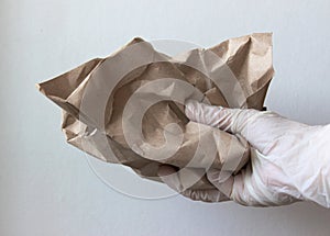 A gloved hand clutches a crumpled paper
