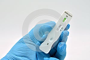 Gloved hand holding an antigen test photo