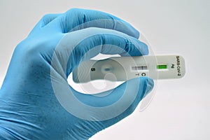 Gloved hand holding an antigen test photo