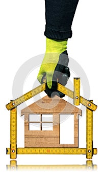 Gloved Hand Holding a Folding Ruler in the Shape of a Wooden House