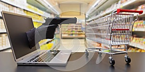 Gloved hand holding gun out of laptop screen aiming empty supermarket trolley. 3d render