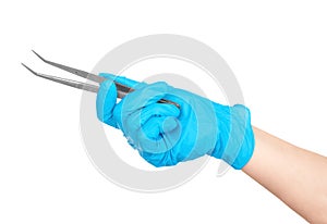 Gloved hand holding a medical tweezers