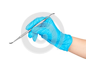 Gloved hand holding a metal dental tool trowel two-way,
