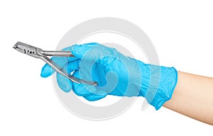 Gloved hand holding a pliers to remove teeth