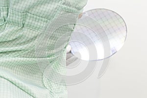 Gloved Hand Holding a Silicon Wafer in plastic holder box used in electronics for the fabrication of integrated circuits