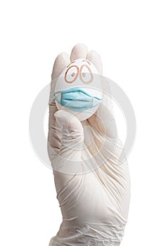 A gloved hand holds an egg in a protective mask. Concept - isolation, holiday without leaving home