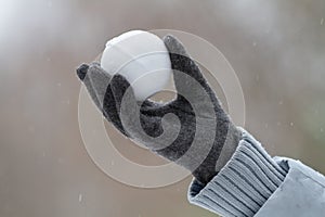 A gloved hand holds a snowball