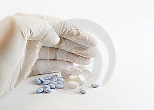 Gloved hand and medicinal pills
