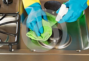 Gloved Hands Cleaning Stove Top Range with Spray bottle and Microfiber Rag