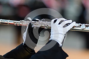 Gloved hands of a flute player in a marching band