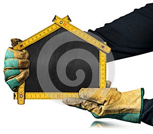 Gloved Hands Holding a Folding Ruler in the Shape of a House