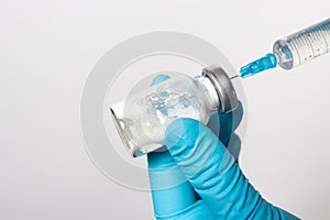 The gloved hands of a nurse dilute the antibiotic with saline. Close-up photo. Step-by-step instruction, step three
