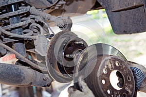 Gloved hands remove or slide the wheel rim onto the hub of the old car.