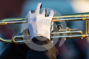 Gloved hands of a trumpet player in a marching band