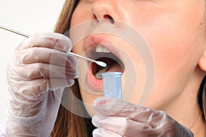 Gloved technician takes a sample of a woman`s saliva from her mouth for DNA analysis, concept of police investigation and medical