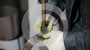 A gloved welder works on a spot welding machine. Chimney welding. An operator works with spot welding to weld a