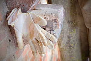 Gloves of an artisan or a peasant hanging on the nail after a day of toil