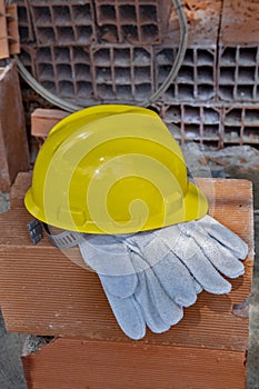 Gloves and protection helmet on pile of bricks photo