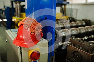 Gloves on red safety helmet in factory