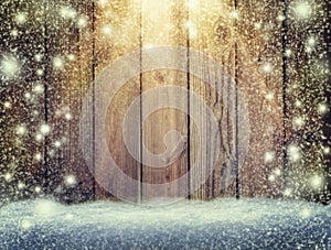 Glow of festive lights and a wooden background in the snow