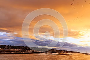 Glow of sunset over river in a windy and rainy winter evening