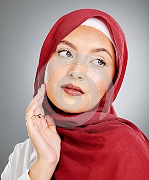 A glowing beautiful muslim woman isolated against grey copyspace background. Young woman wearing a hijab or headscarf