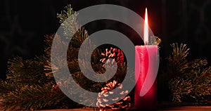 Glowing candle with Christmas decoration