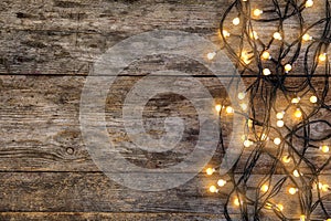 Glowing Christmas lights on wooden background