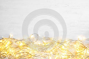 Glowing Christmas lights on wooden background