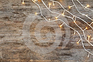 Glowing Christmas lights on wooden background