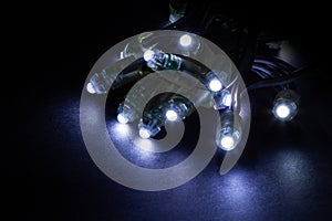 Glowing cold white led pixels christmas holiday lights on black background