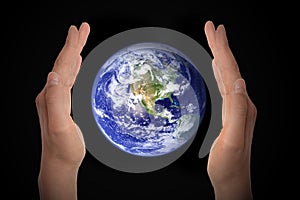 Glowing earth globe in hands on black, environment concept - elements of this image furnished by NASA photo